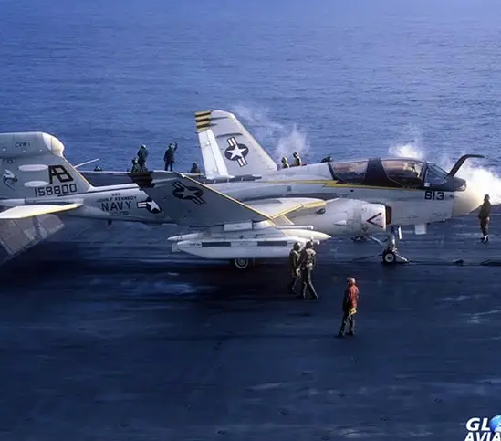 A fighter jet is on the deck of an aircraft carrier.