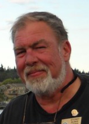 A man with a beard and mustache wearing a black shirt.