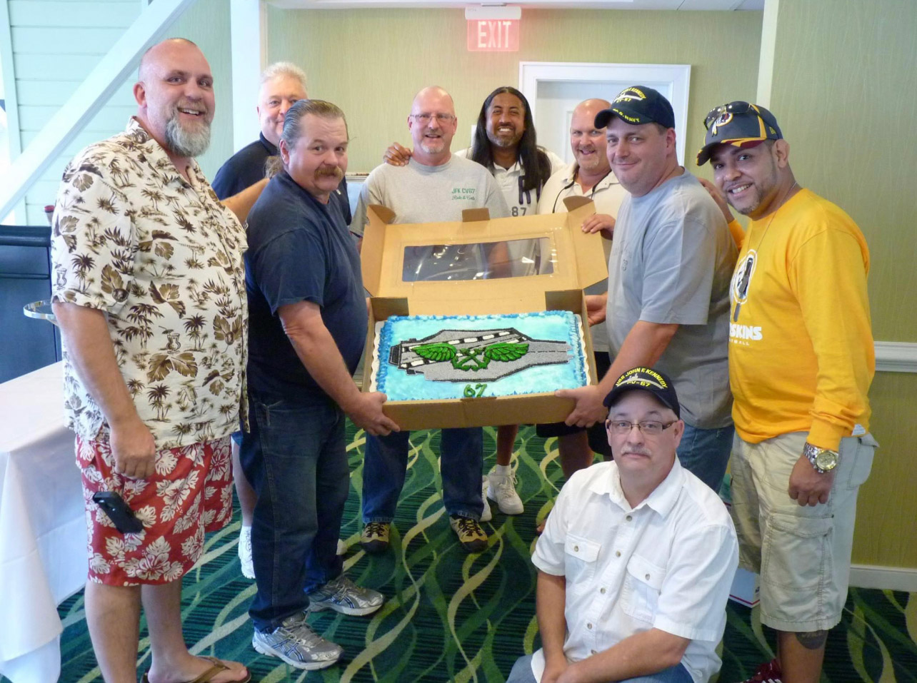 A group of men holding a box with a fish on it.