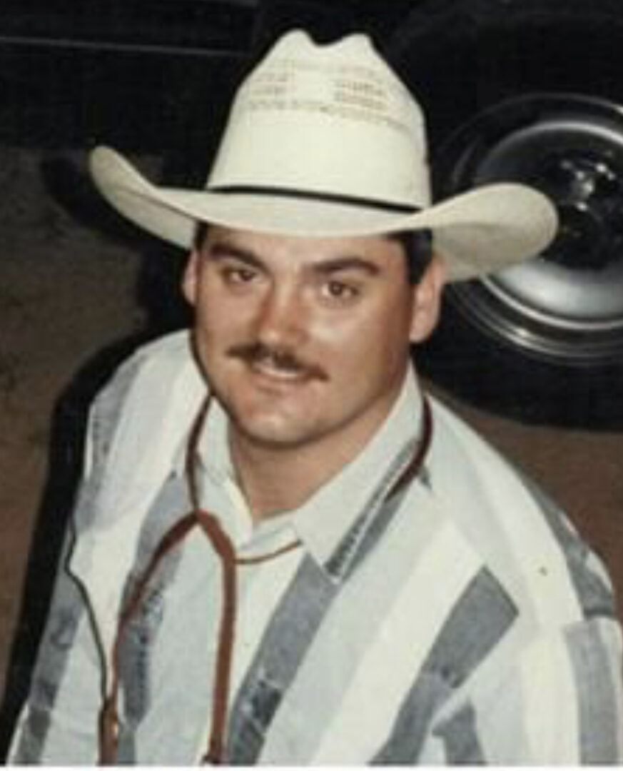 A man in a cowboy hat and striped shirt.