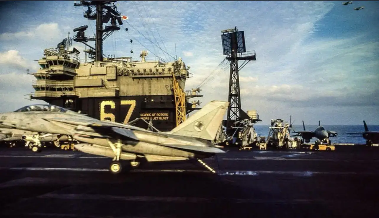 A fighter jet on the deck of an aircraft carrier.