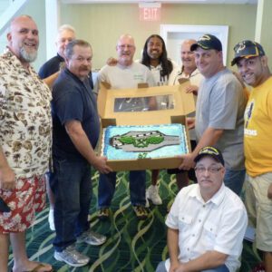 A group of men holding up a box with a fish inside.